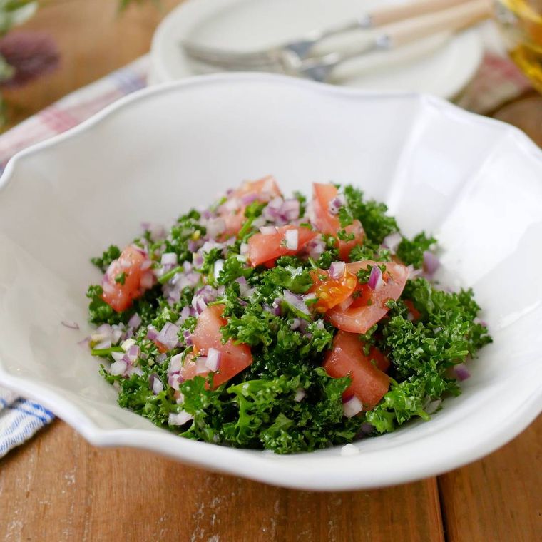 白い洋食器に盛り付けたパセリとトマトのサラダ