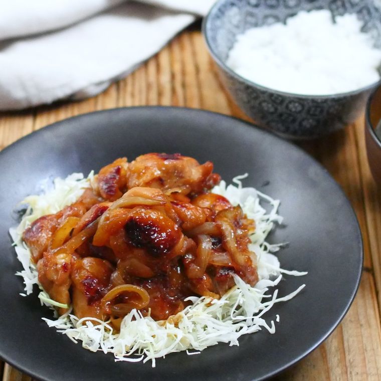 黒い皿に盛り付けた鶏もも肉のしょうが焼き