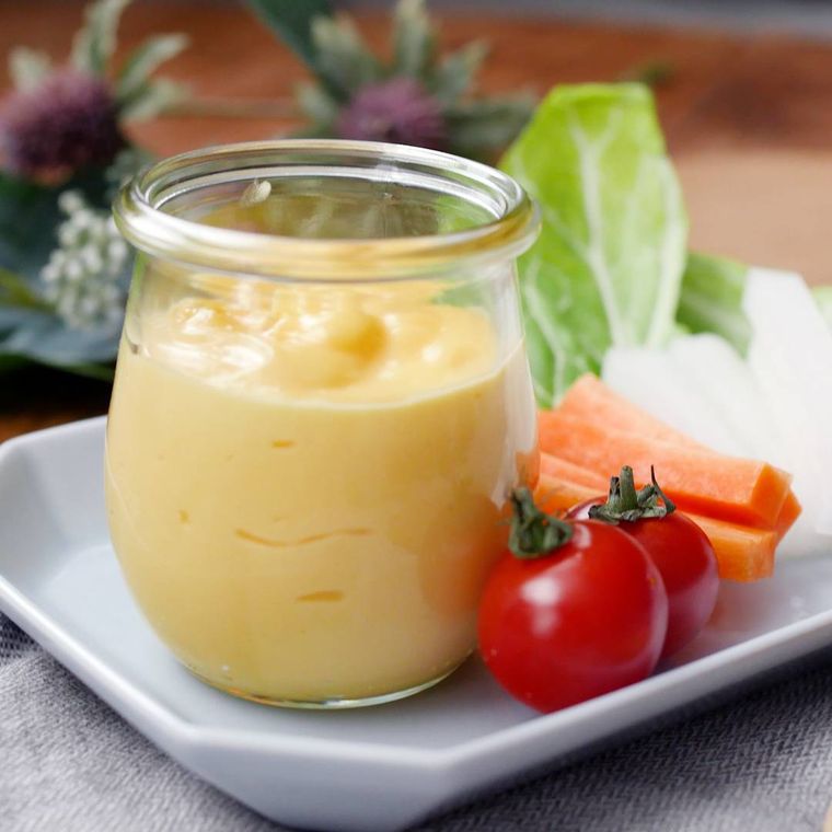 生野菜を添えた、透明な瓶に入ったマヨネーズ