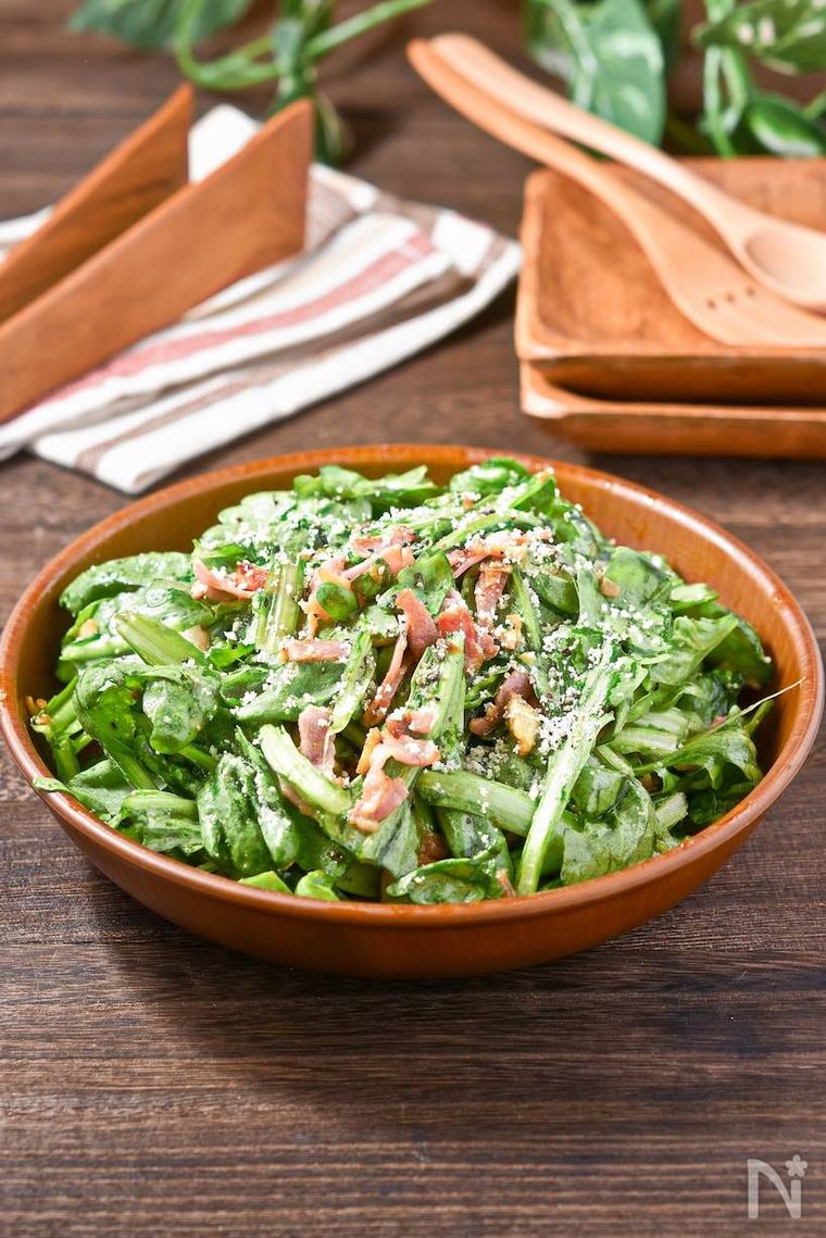 ベーコンと粉チーズがトッピングされた春菊のサラダ