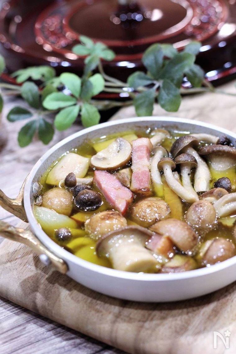 白いスキレットに入れられたきのことベーコンのアヒージョ