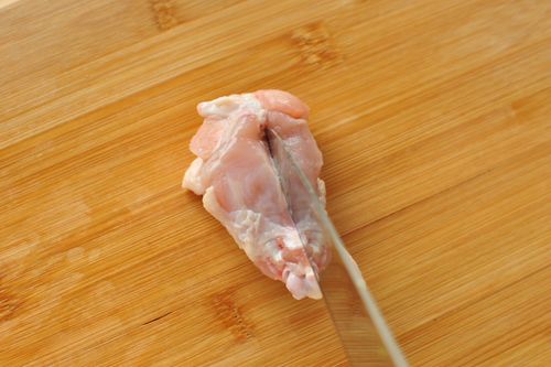 手羽元の骨に沿って包丁を入れる様子