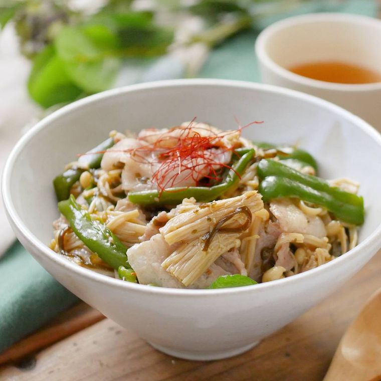 白い丼鉢に盛りつけられた豚肉とえのきだけの塩こんぶバター丼