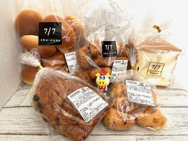 食パン、ロールパンなどのたくさんのパンがテーブルに置いてある