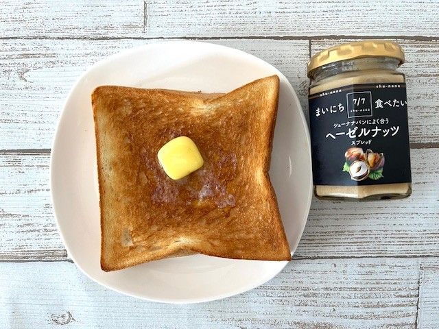大きなバターをのせたトーストとヘーゼルナッツのスプレット瓶