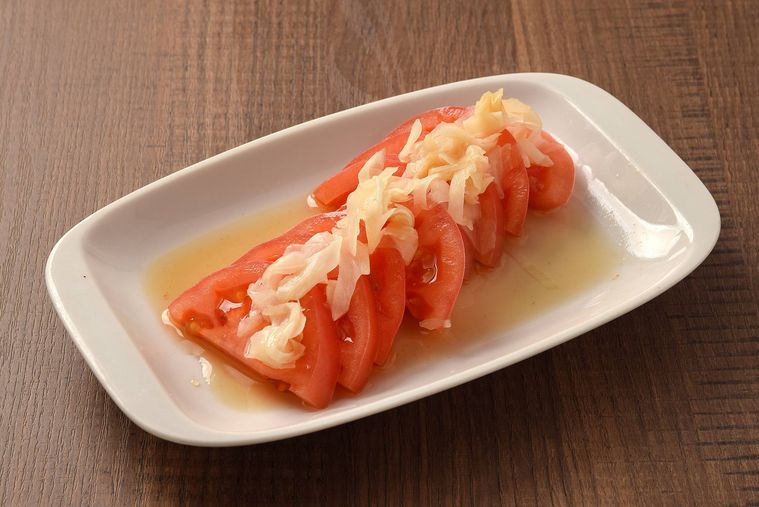 冷やしトマトの上にガリがトッピングされている