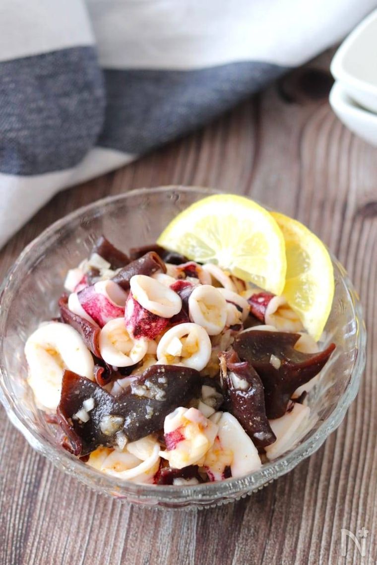 ガラス製の器に盛られたいかときくらげのピリ辛ごまレモンマリネ