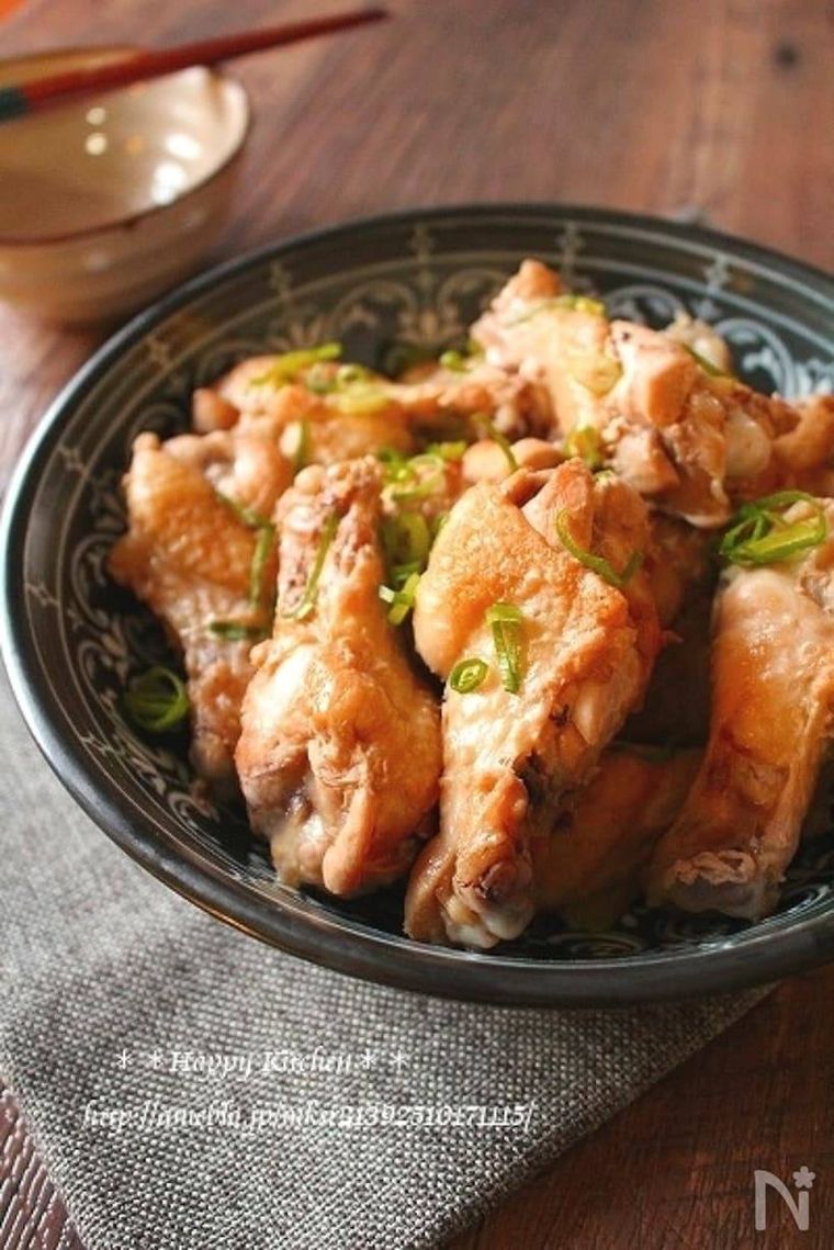 手羽元の柚子胡椒照り焼きを深緑色の器に盛り、小口ねぎを散らした様子