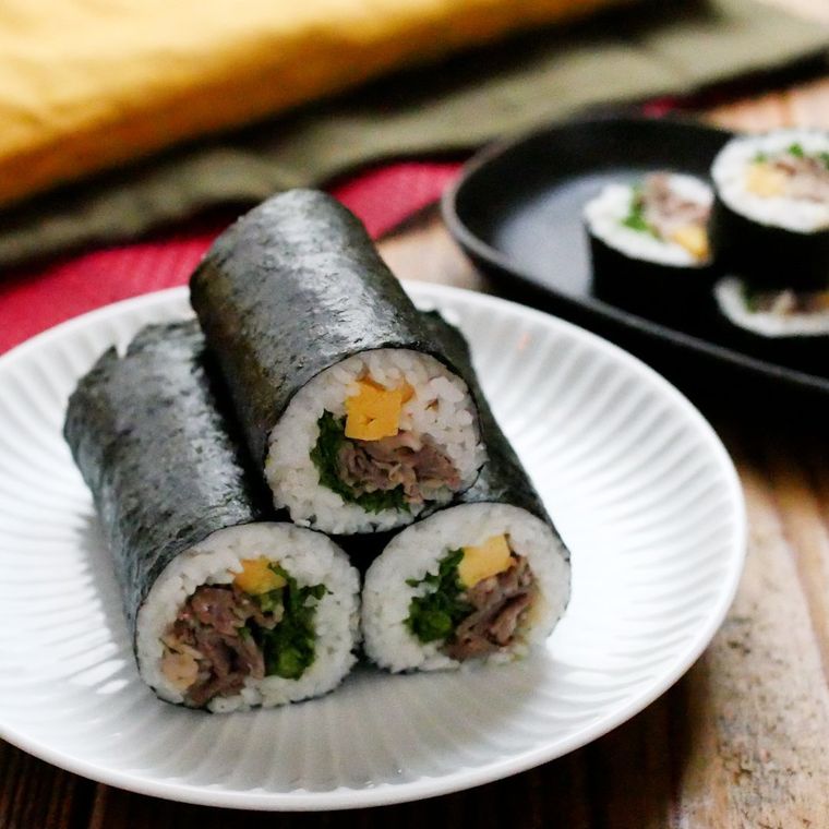 白い皿に重ねて盛った3本の恵方巻き