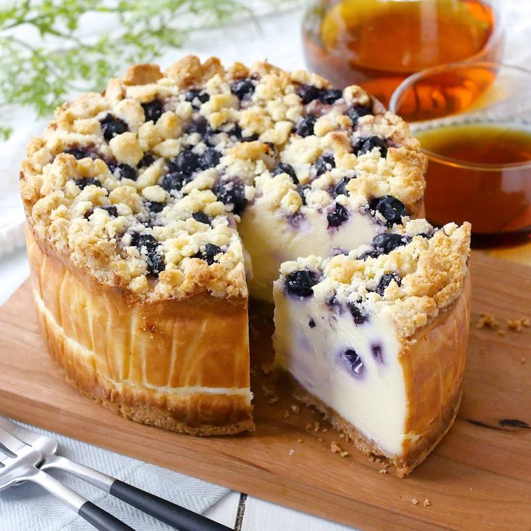 木製のカッティングボードにのったブルーベリーのベイクドチーズケーキ