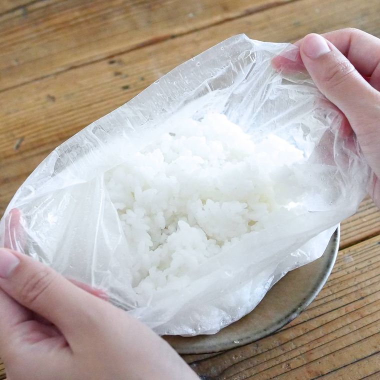 炊かれたごはんが入っているポリ袋を手で持って広げる様子