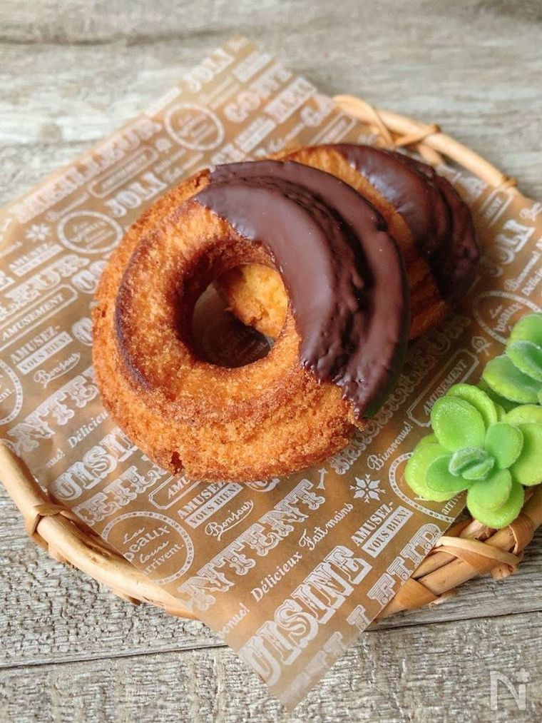 英字の書かれたクッキングシートにのせた2個のオールドファッション