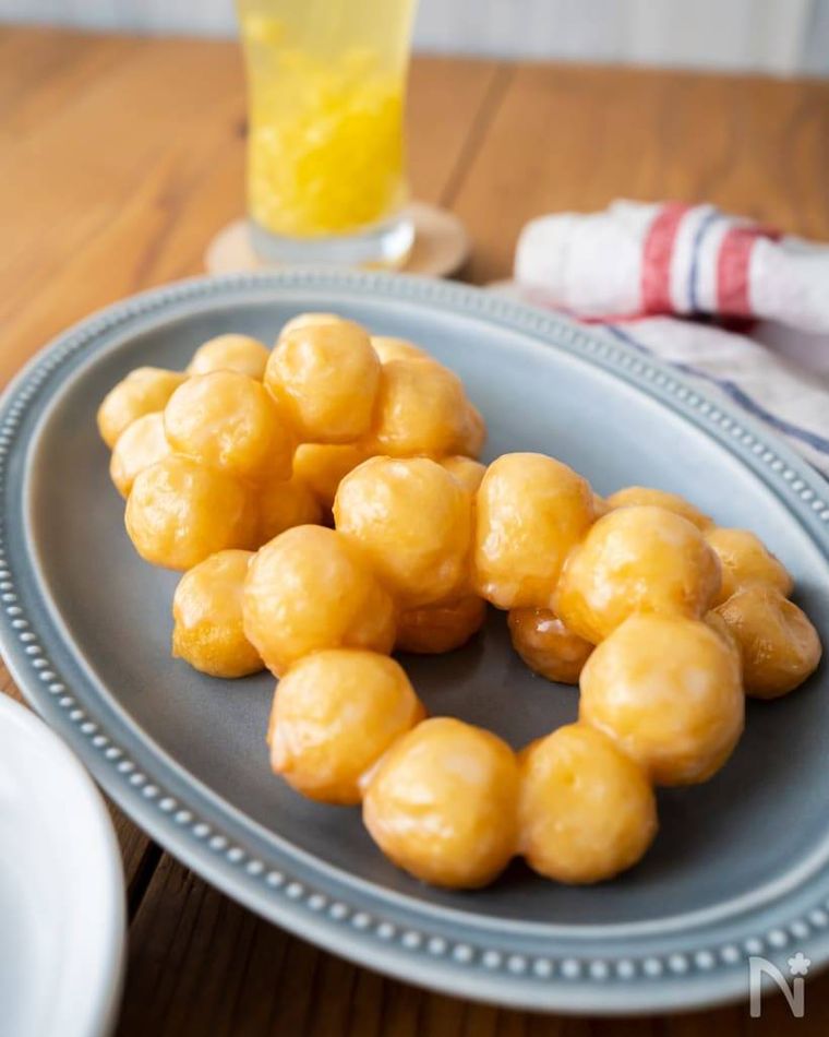 グレーの器に並べられたミスド風ポンデリングとジュース