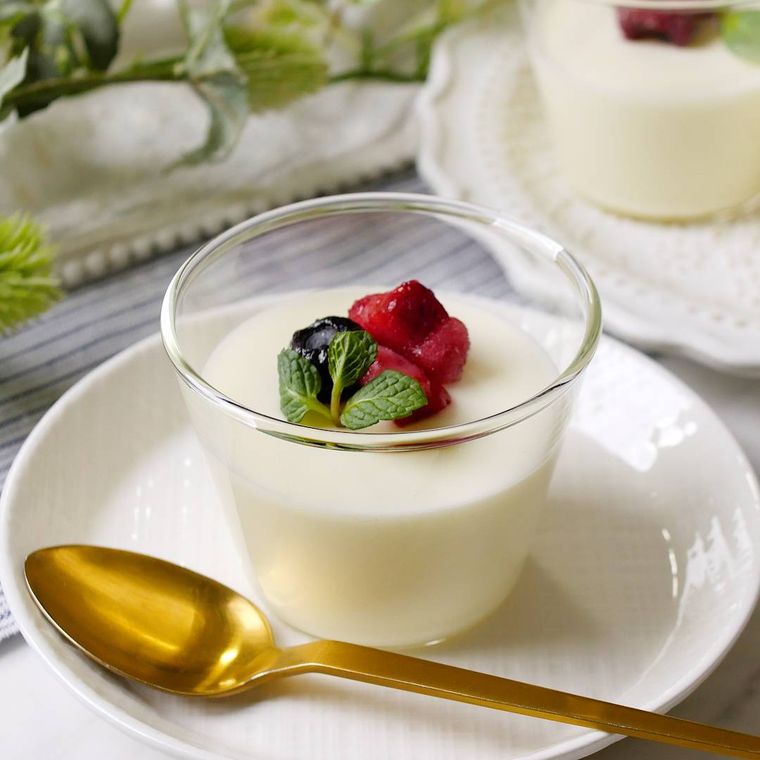 ガラスの器に入ったヨーグルトムースのベリーとミント添え