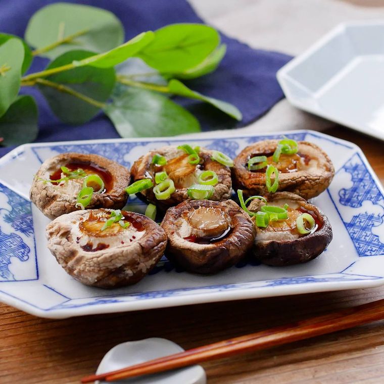 白地に青い模様入りの皿に盛られた焼きしいたけ