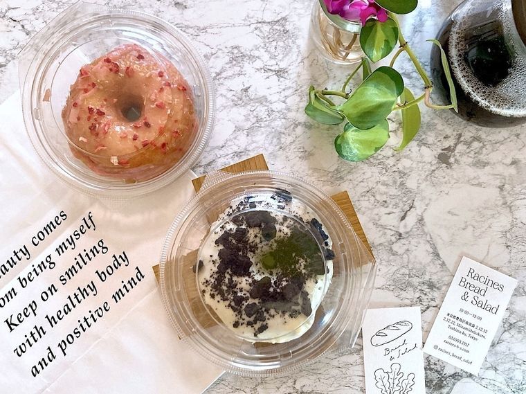 ケースに入った池袋ラシーヌブレッドサラダのドーナツ2個と袋、ショップカードを並べたところ