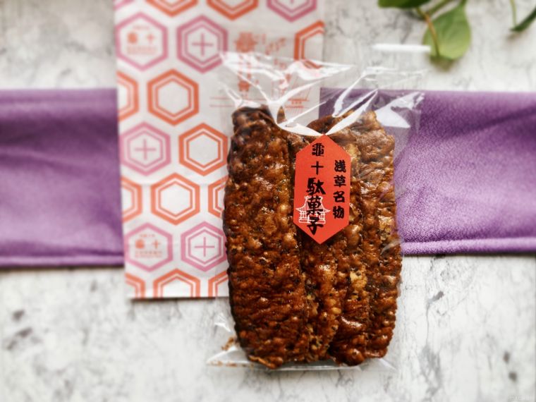 亀十の紙袋とうすばかりんとうをたたんだ風呂敷の上に置いたところ