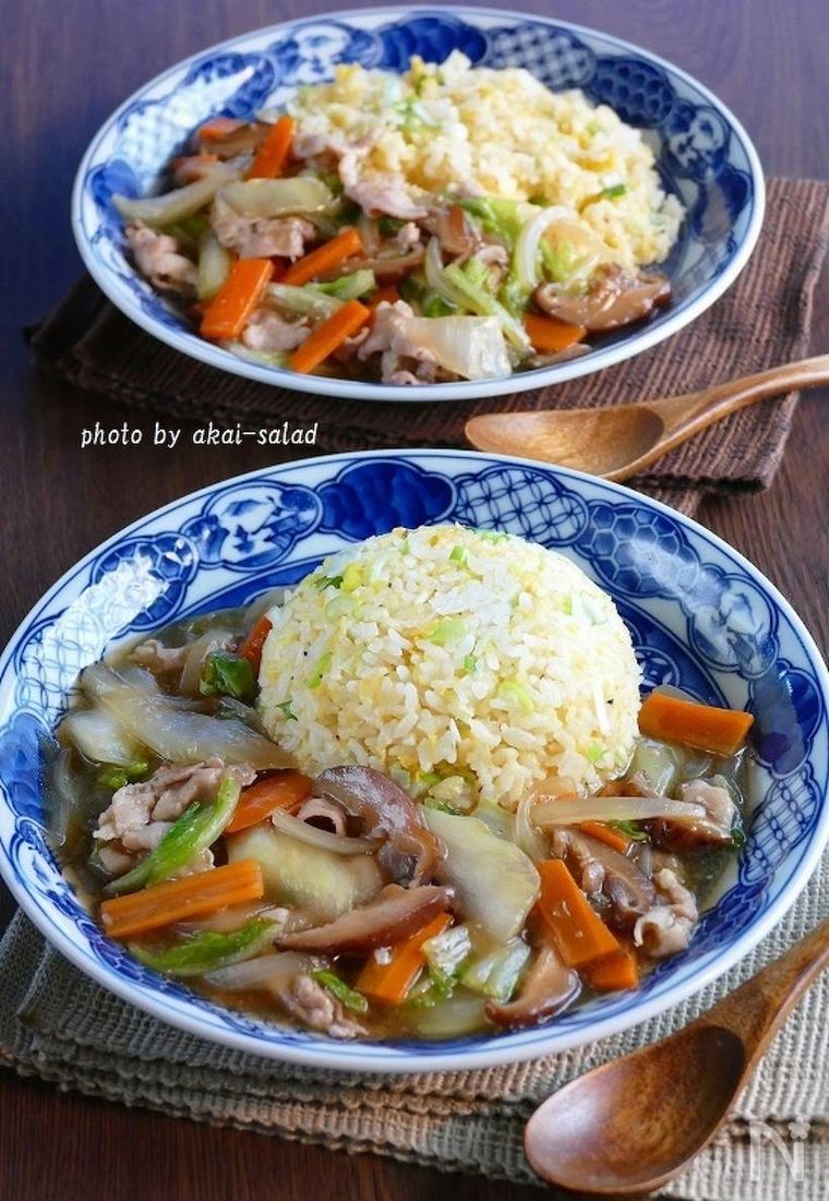 青い絵柄が入った器に盛られた豚バラ白菜あんかけ炒飯と木製のれんげ