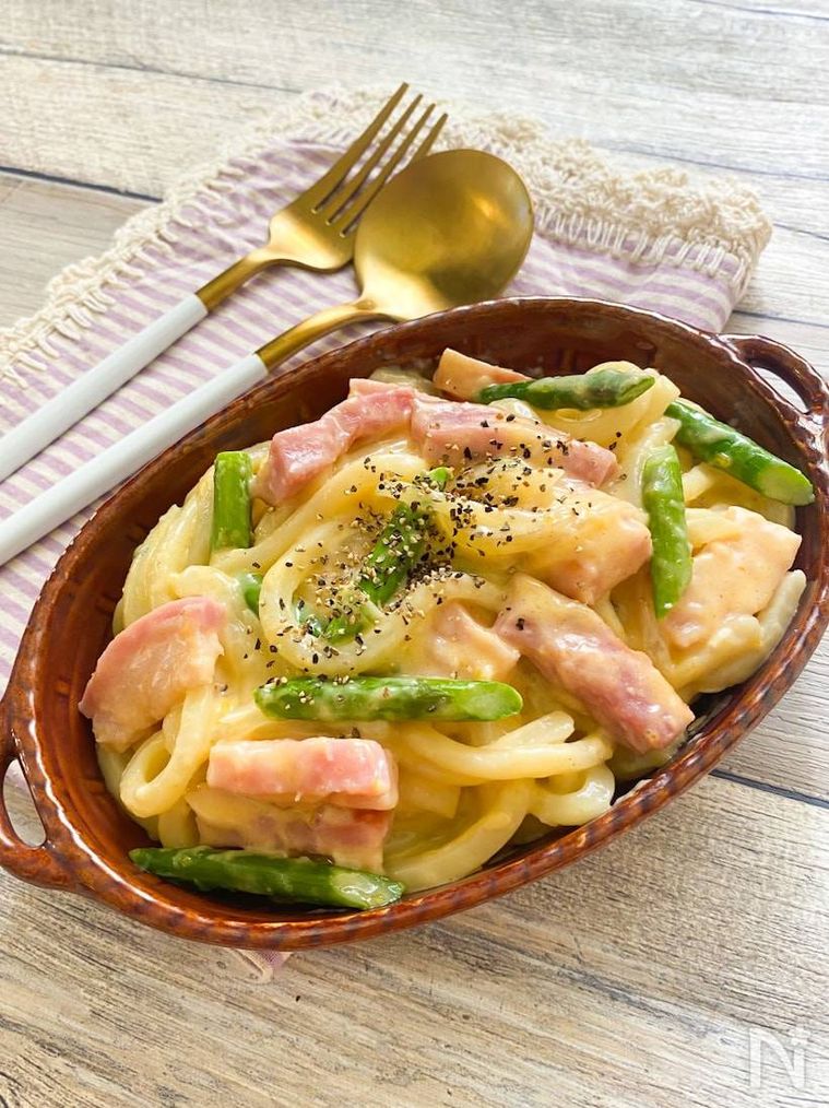 茶色いグラタン皿に盛り付けられたレンジで濃厚カルボナーラうどん