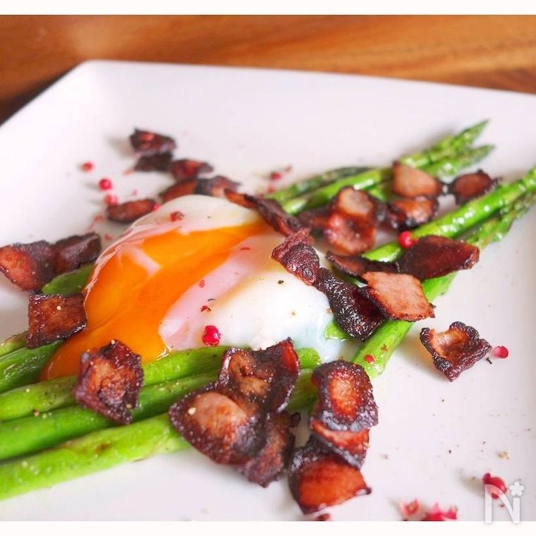 白い四角形の器に盛られた温玉アスパラベーコン