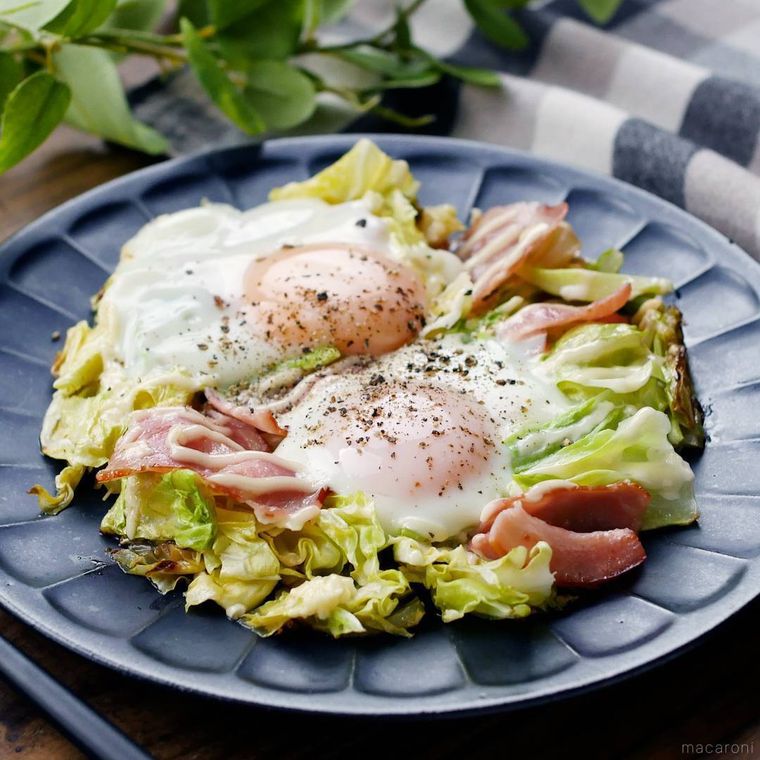 灰色の丸皿に盛られた春キャベツたっぷりベーコンエッグ
