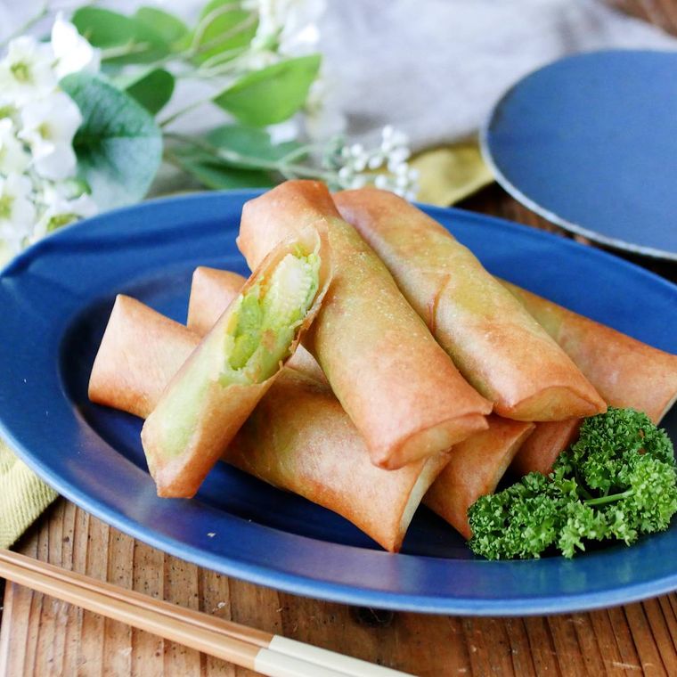 青いオーバルの器にヤングコーンのアボカド春巻きとパセリがのっている