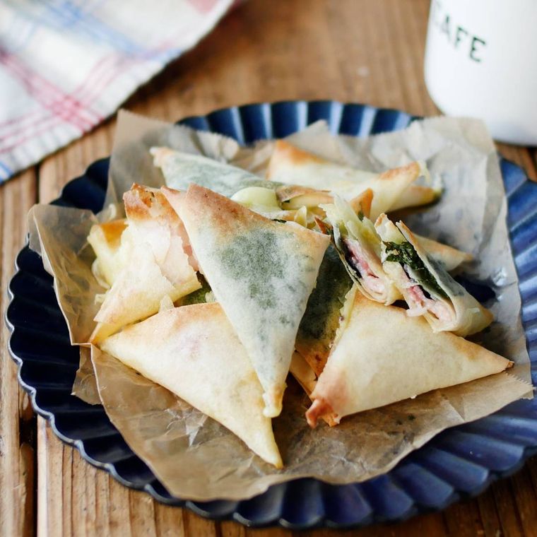 青い器にベーコンチーズ春巻きがたくさん乗っている