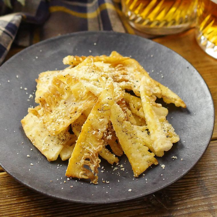 黒い丸プレートに盛り付けた、たけのこチーズチップス