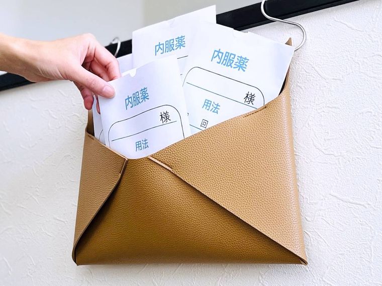 スリーコインズのお薬ストックケースにお薬袋を入れている様子