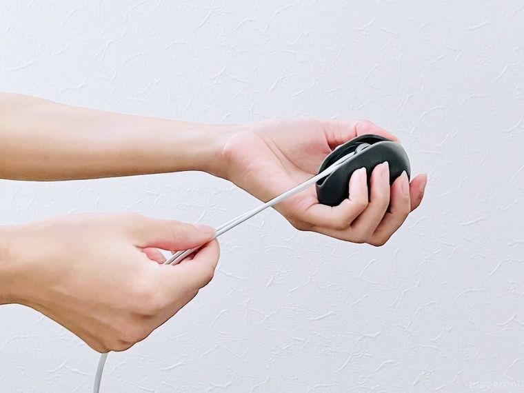 ケーブルを引っ張ってケースに巻き取っているところ