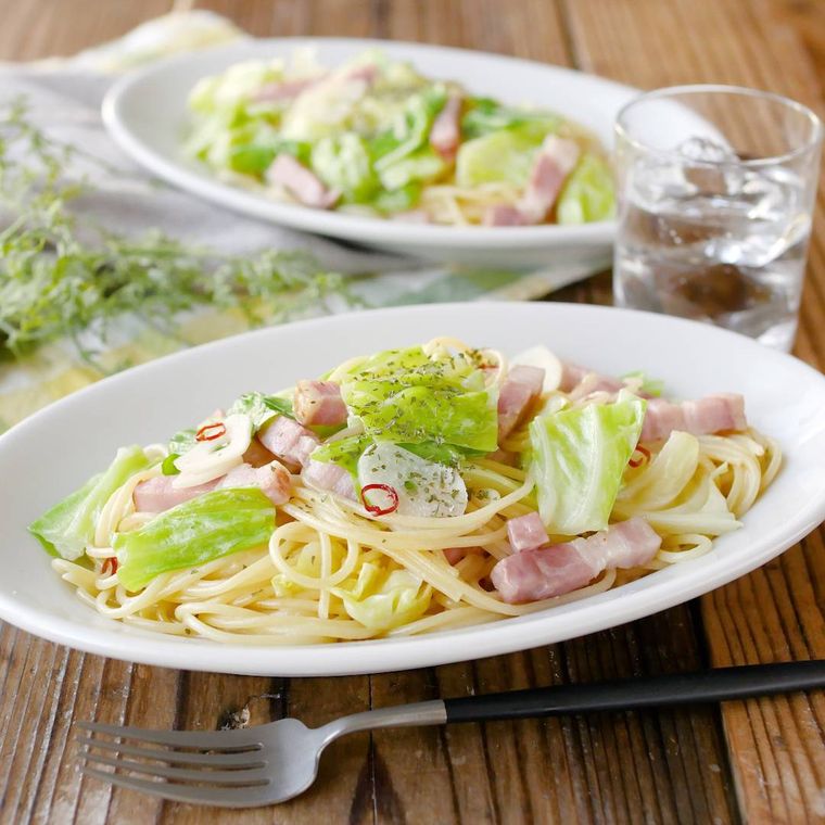 白いオーバルの皿に春キャベツとベーコンのペペロンチーノのパスタが入っている