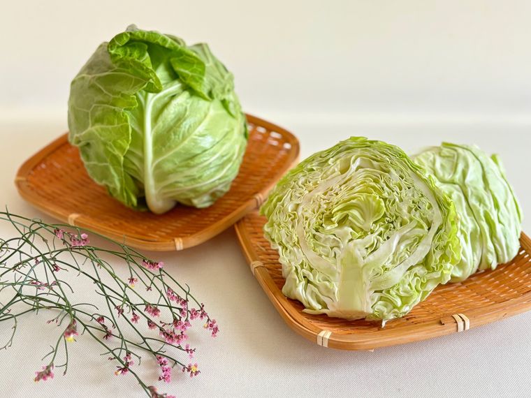 テーブルにおかれた丸ごとの春キャベツ、カットした春キャベツ