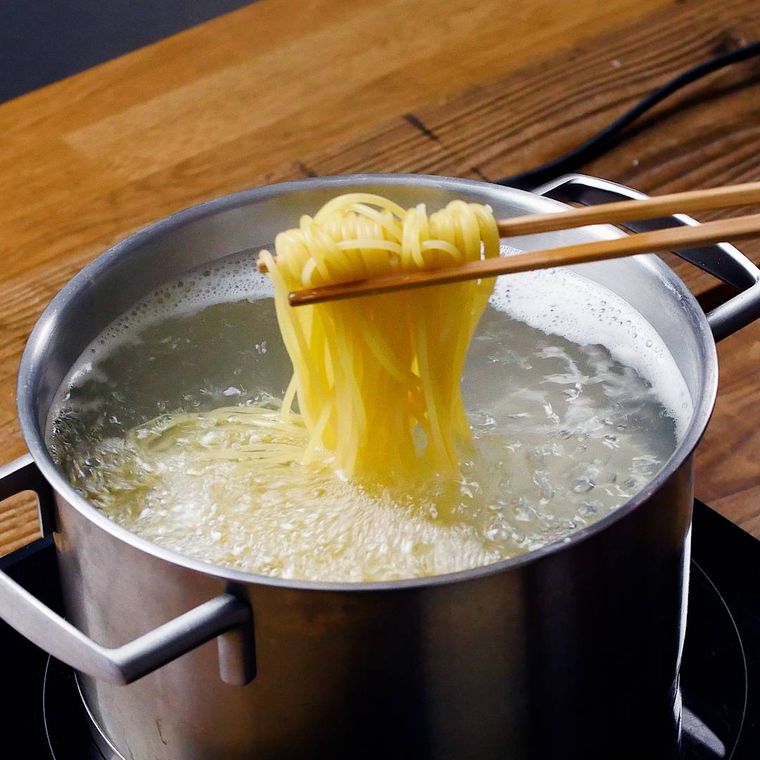 菜箸で持ち上げているゆでているパスタ