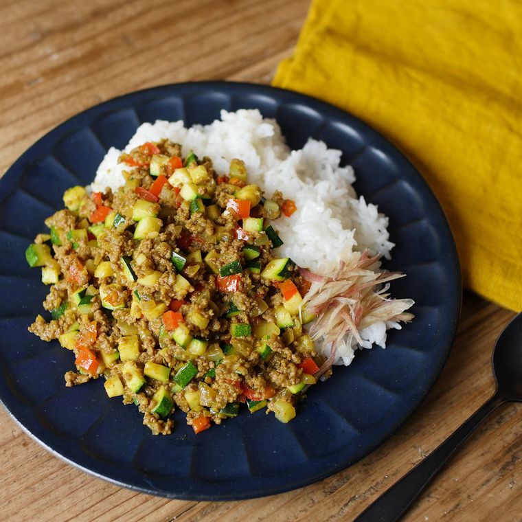 青い丸皿に盛り付けたズッキーニとパプリカのキーマカレー