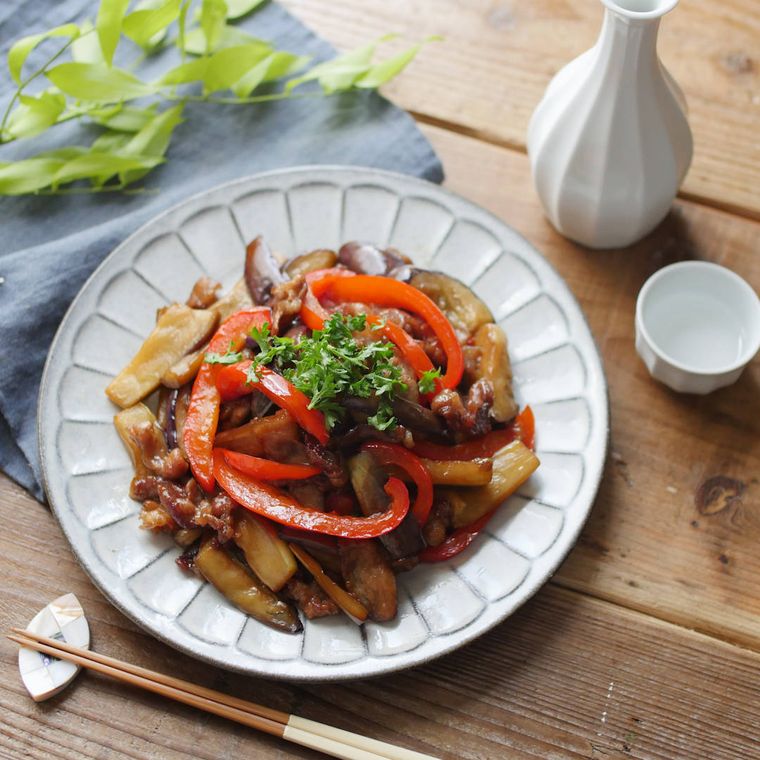 グレーの皿に入った豚肉となすの照りポン炒め