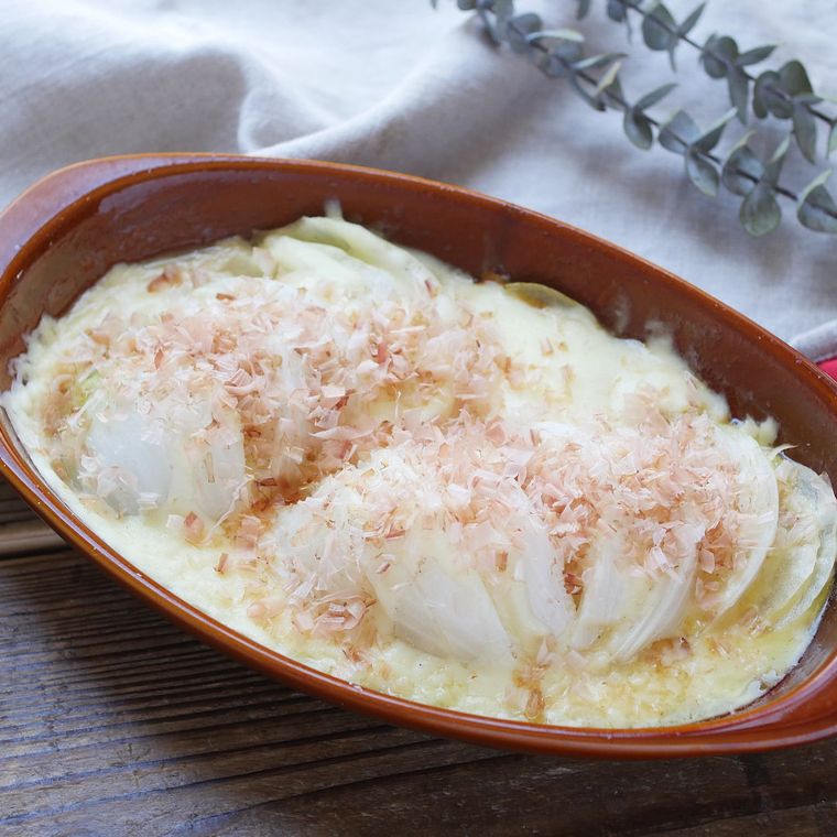 甘み際立つ玉ねぎのチーズ焼きが赤い皿に入っているところ