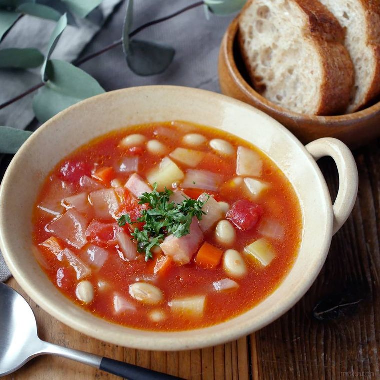 白色のスープボウルに入った大豆と野菜のミネストローネ