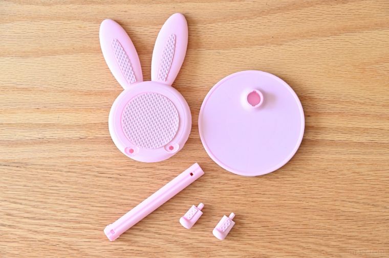 木のテーブルに並べられたピンク色のパーツ