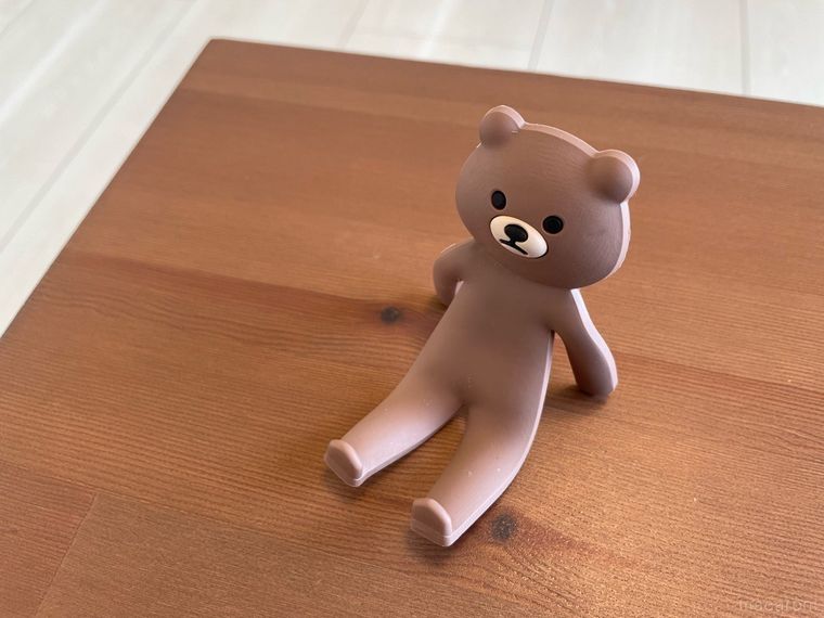 座っているような姿勢で置かれたクマのスマホスタンド