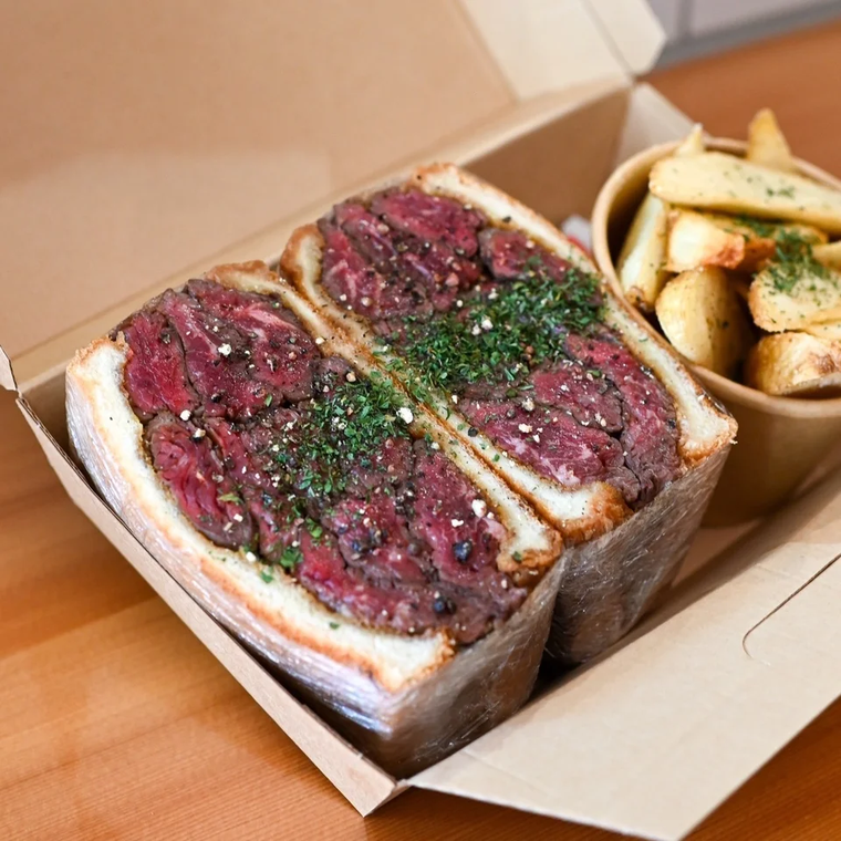 肉が挟まったサンドイッチミートボックスとフライドポテト