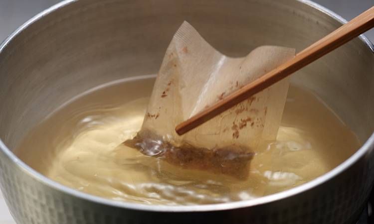 だしパックを箸で掴んでいる様子