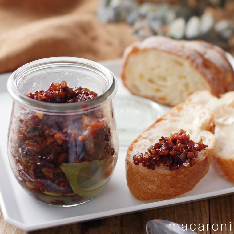 瓶つめされたベーコンジャムと、スライスしたパンにのったベーコンジャム