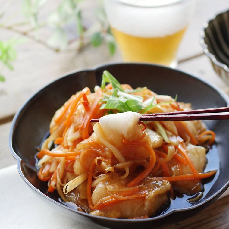 黒い皿に盛られた揚げ餅とにんじん、玉ねぎの南蛮酢