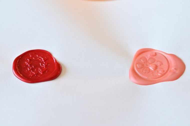 紙に押した赤とピンクのシーリングスタンプ