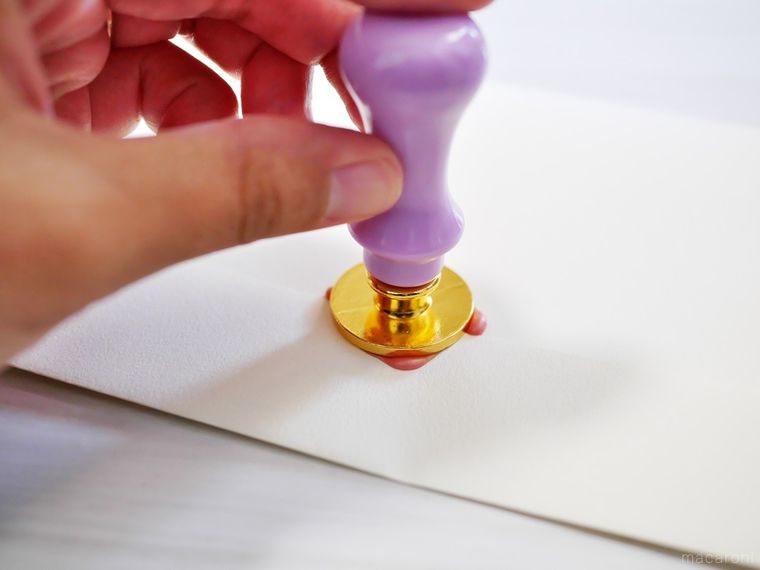 紙にシーリングスタンプを押している