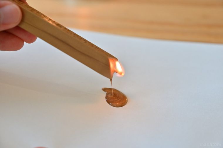 スティックタイプのワックスを紙の上に垂らしている
