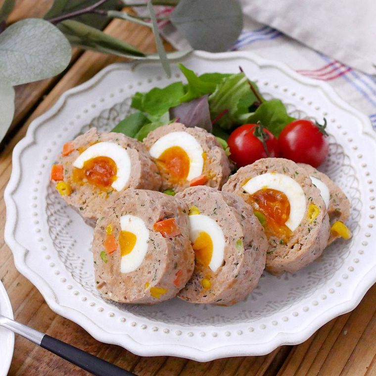 白い皿に入ったゆで卵入りミートローフの断面