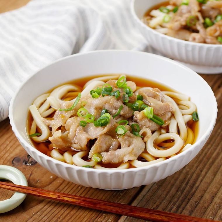 白い丼に入った甘辛肉うどん