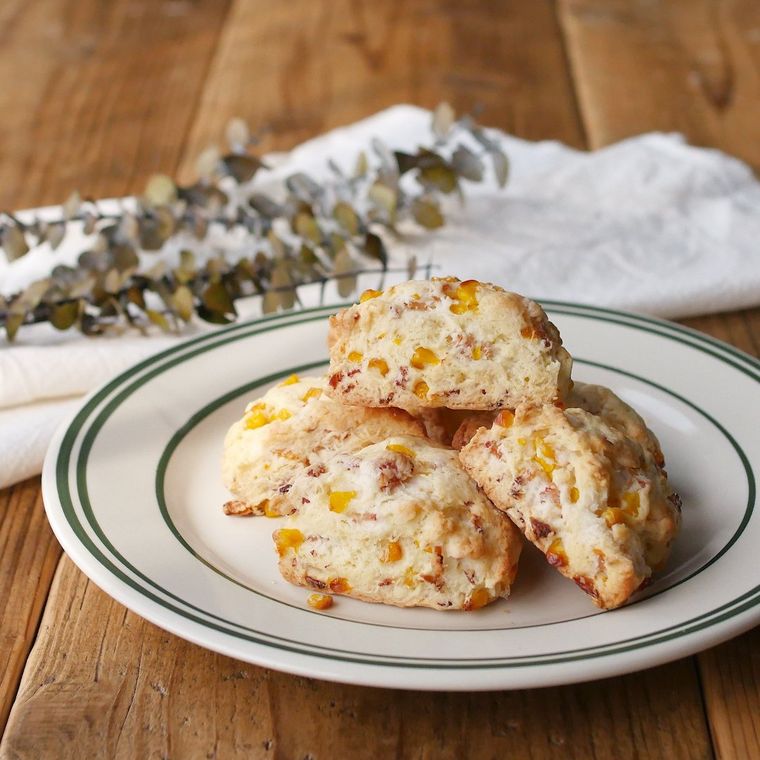 マヨネーズを使ったハーフベーコンとコーンが入ったスコーンが白い皿に盛り付けられているところ