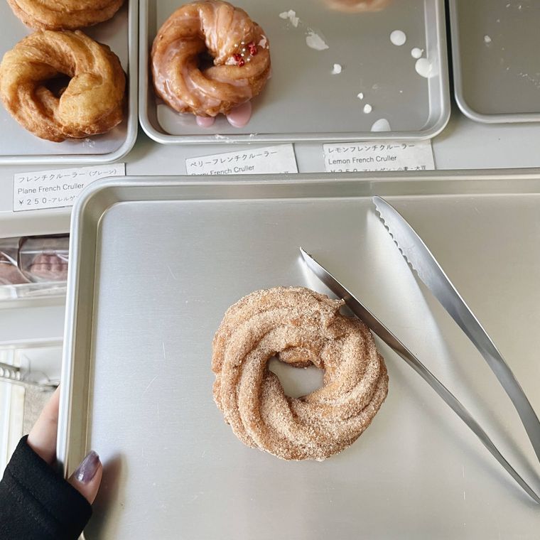 トングとトレーにのったフレンチクルーラー